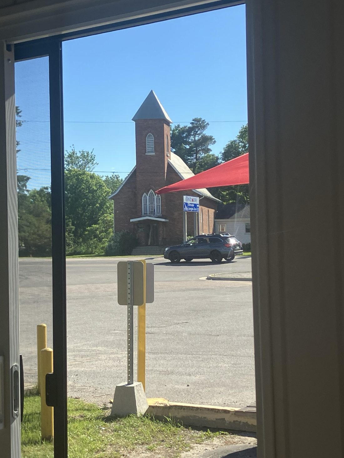 View from the Bistro 93 doorway across the street to a brick church with a steeple